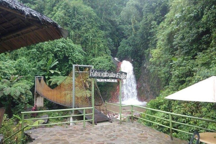 A rope bridge, a sign for Pulang Bato Falls, and a waterfall. 4