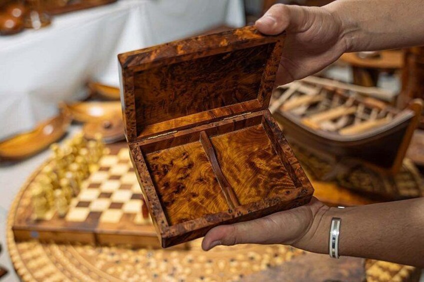 Una caja de madera con divisiones, sostenida por una persona. 1