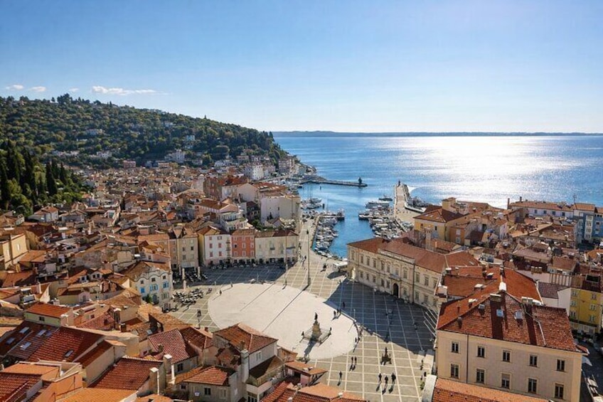 A coastal town with a central square, historic buildings, and a marina. 5