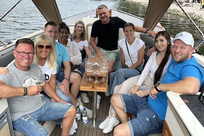 A group of people on a boat with a table in the center. 2