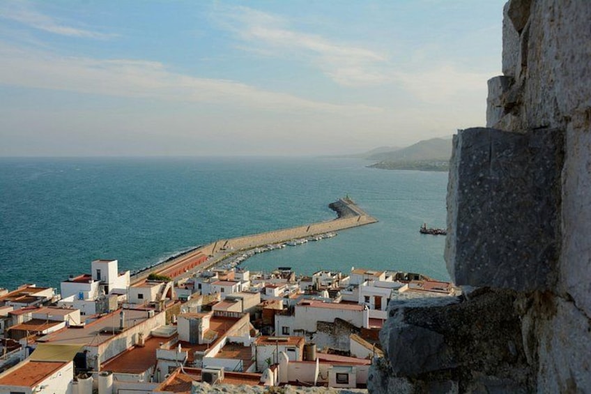 A coastal town with buildings, a pier, and the sea. 2