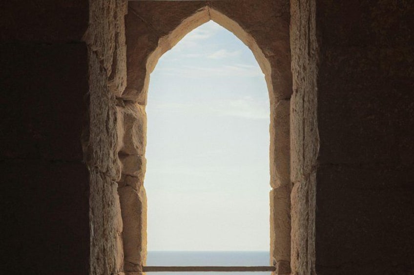 A stone archway with a view of the sky and horizon. 4