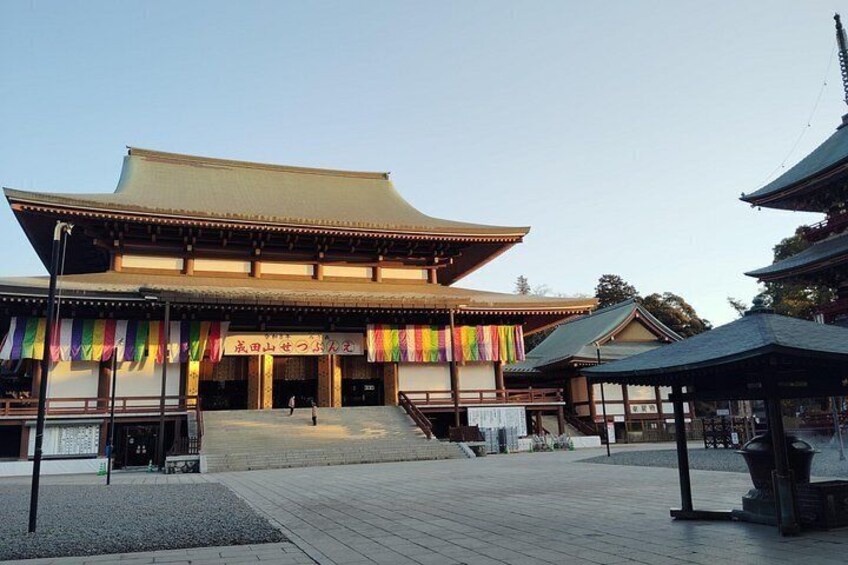 Un edificio japonés tradicional con techo de tejas y coloridos estandartes. 3