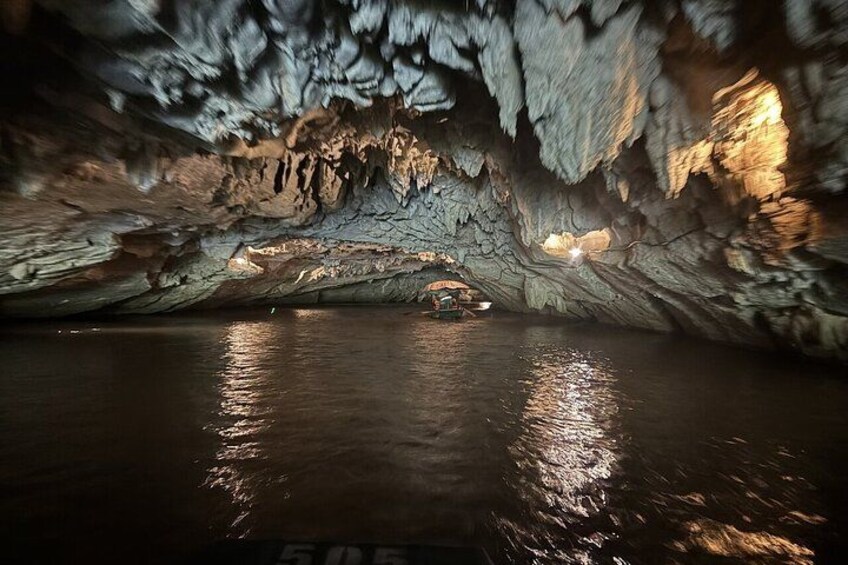 Una cueva con estalactitas y un bote en el agua. 4