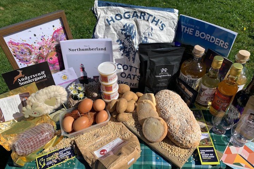 A variety of food items, including eggs, bread, and bags of oats, displayed on a table outdoors. 3
