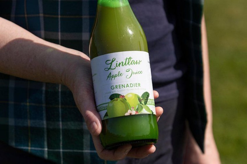 A person holding a bottle of Linlawn Apple Juice Grenadier. 2