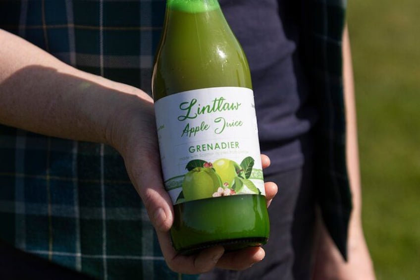 A person holding a bottle of Linlawn Apple Juice Grenadier. 4