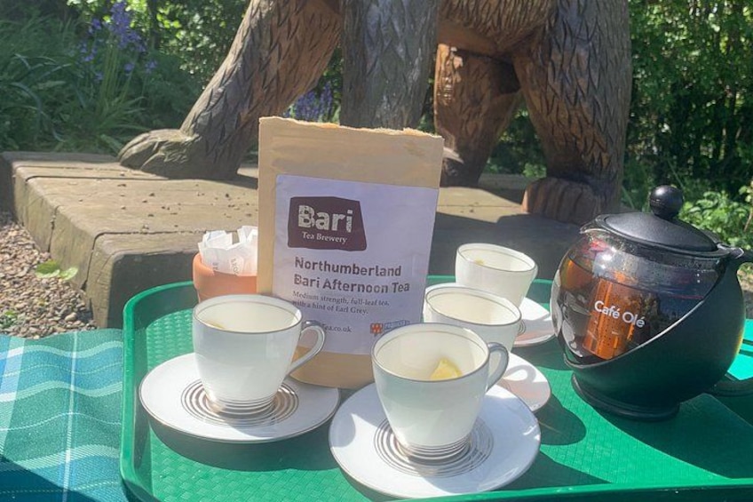 A table with tea cups, a teapot, a bag of tea, and a sign for Bati Tea Brewery. 5