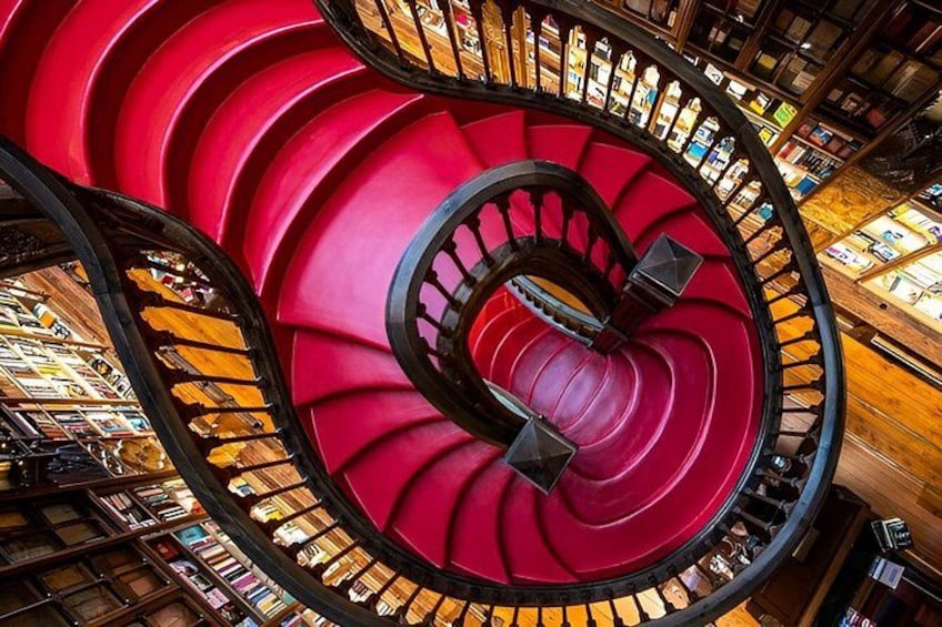 A spiral staircase with red steps and black railings in a library. 2