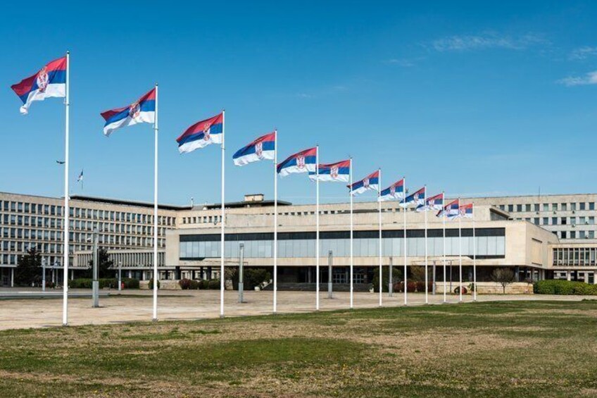 Ein modernes Gebäude mit mehreren Flaggen davor. 1