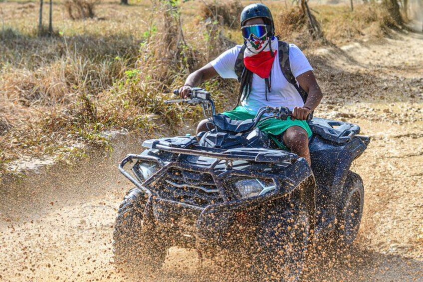 A person riding an ATV on a dirt path. 1