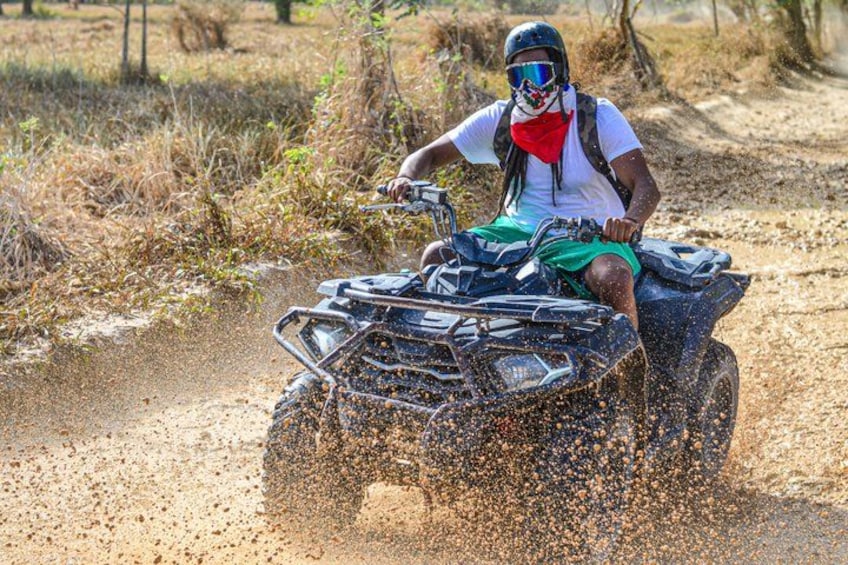 A person riding an ATV on a dirt path. 1
