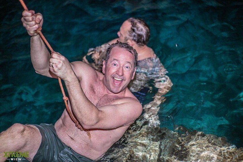 A person in a swimming pool holding onto a rope. 3