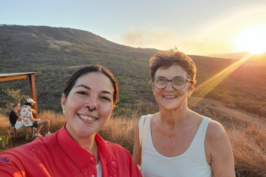 Deux personnes prenant un autoportrait avec un coucher de soleil en arrière-plan. 1