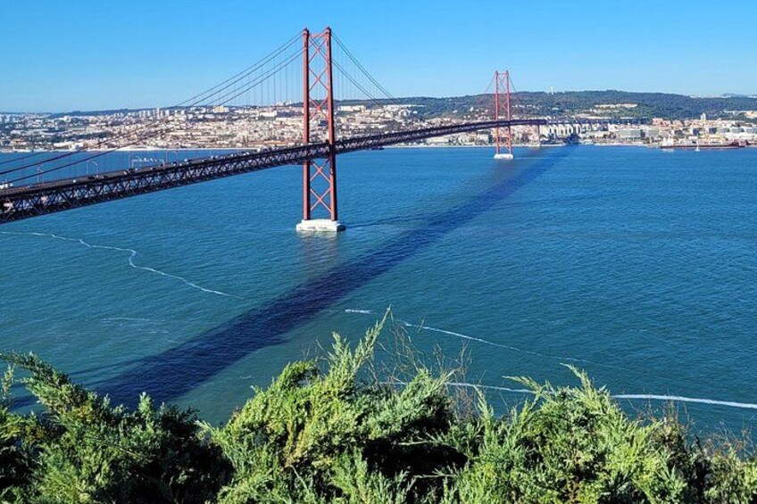 A large suspension bridge over a body of water with a cityscape in the background. 3