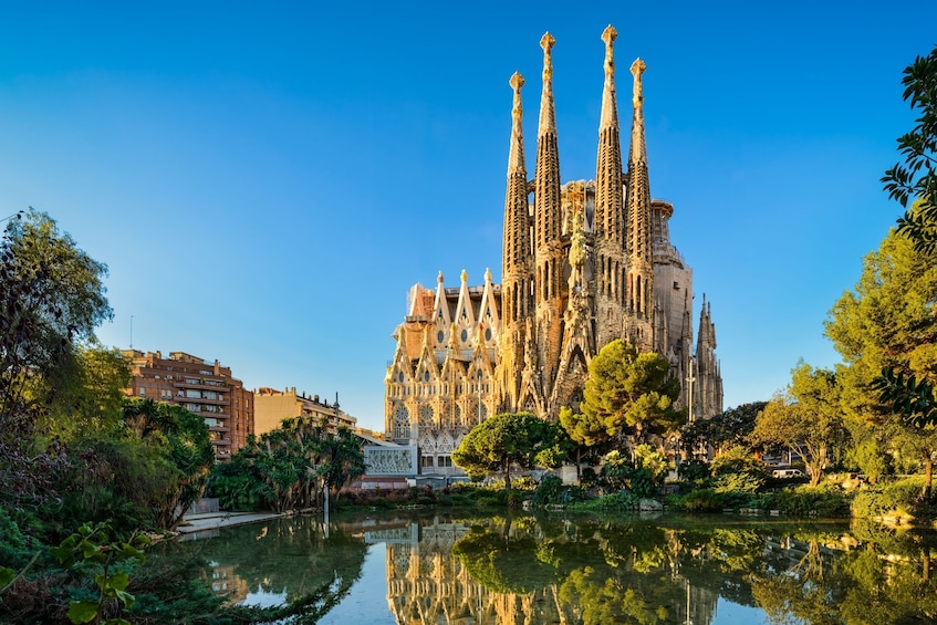 Sagrada Familia -kirkko, sen monimutkaiset tornit ja niiden heijastus vedessä. 1