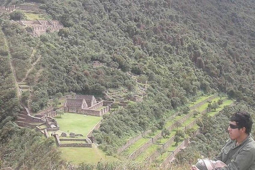 A mountainous landscape with a large ancient structure surrounded by terraced fields. 1