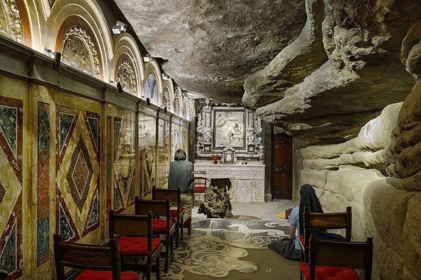 An interior with arched ceilings, patterned walls, and a central altar. 1
