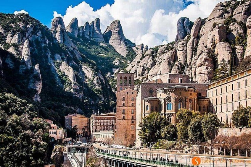 A mountainous landscape with a historic building featuring a tower and arched windows. 3
