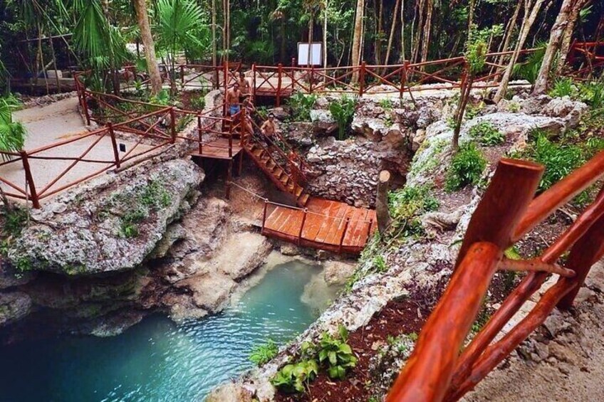 A wooden bridge over a natural pool with surrounding vegetation. 4