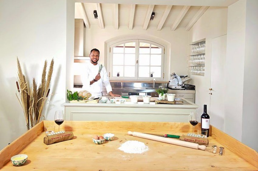 A chef in a kitchen with a wooden countertop, a window, and kitchen appliances. 2