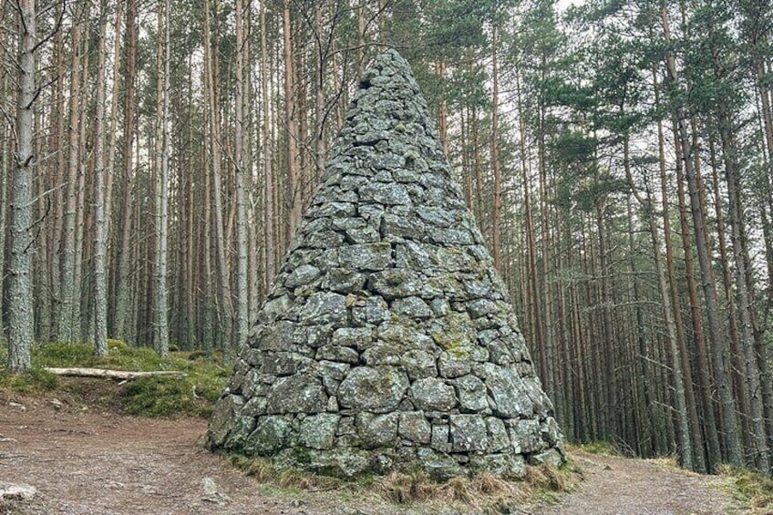 A stone cairn in a forest. 5