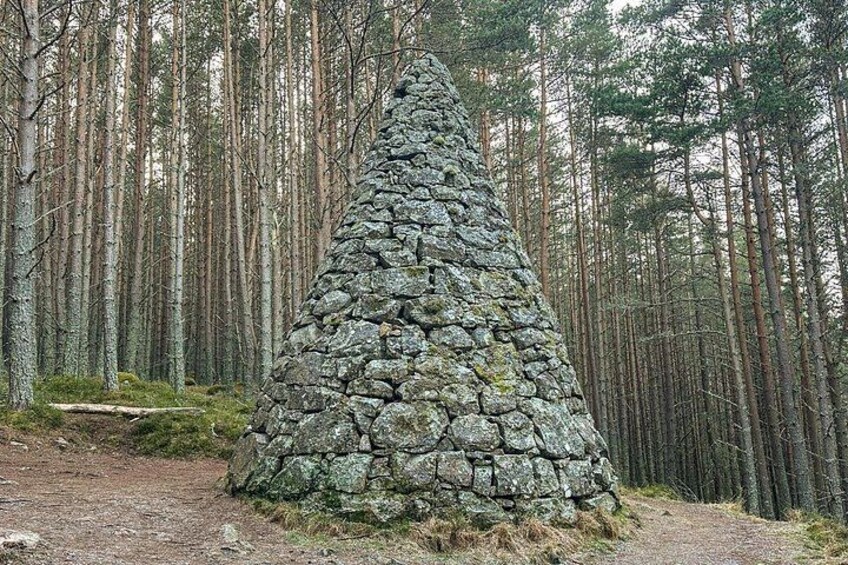 A stone cairn in a forest. 5