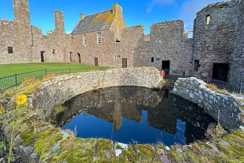 A stone bridge over a reflective water body, surrounded by historic stone buildings. 3