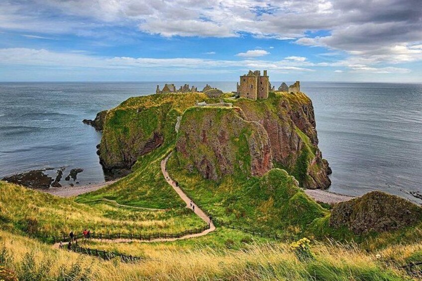 A coastal castle on a cliff, a winding path, and the ocean. 4