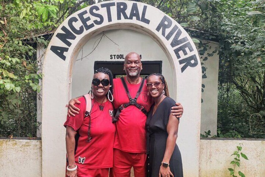 Three people standing in front of a sign that reads "ANCESTRAL RIVER." 1