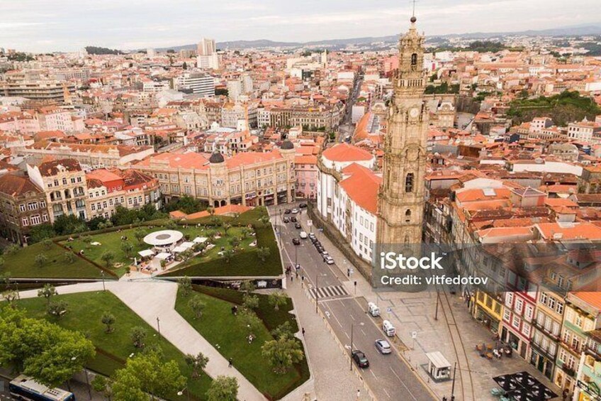 Un paisaje urbano con una torre destacada, un espacio verde central y una calle concurrida. 5