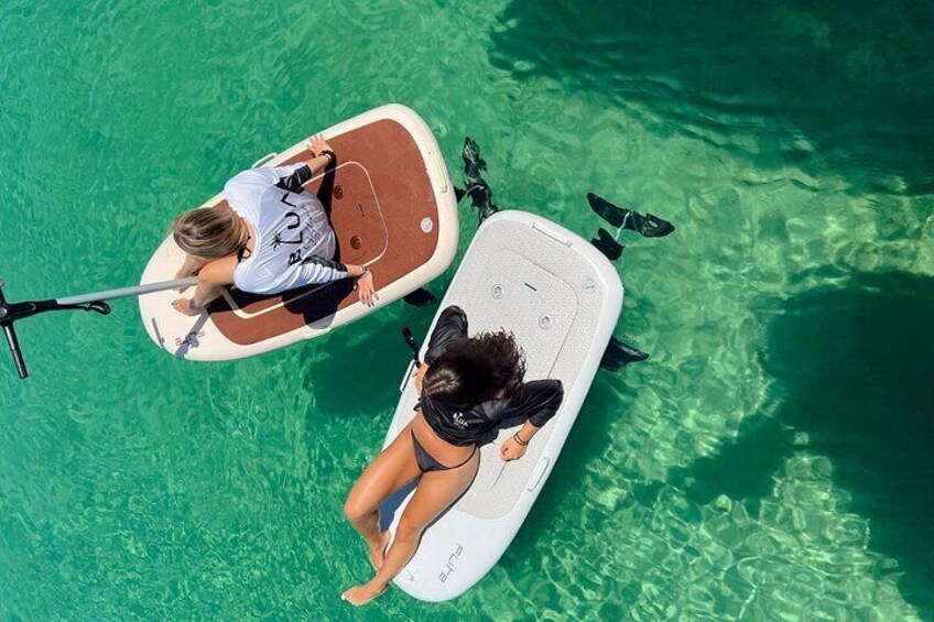 Two people on paddleboards in clear water. 1