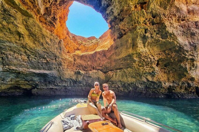En båt i en klippig grotta med två personer. 2