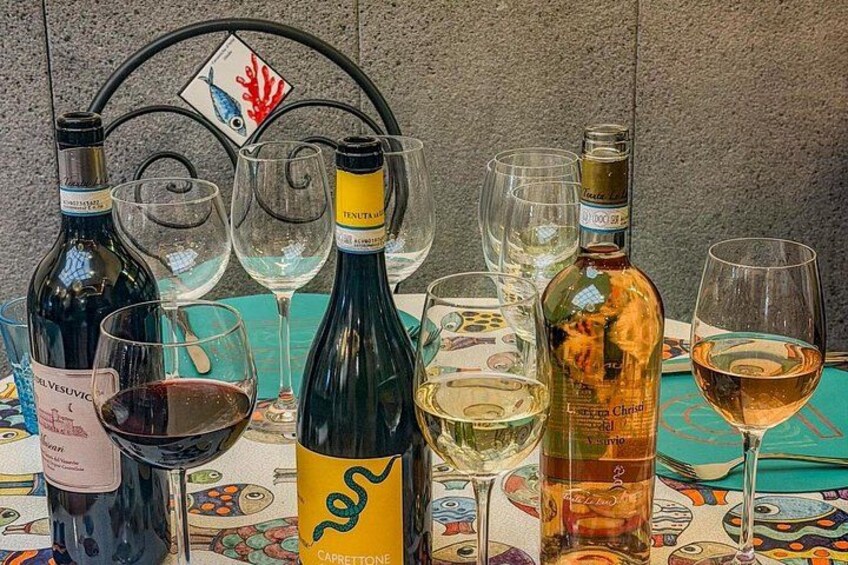 A table with wine bottles and glasses, a decorative metal frame, and a patterned tablecloth. 4