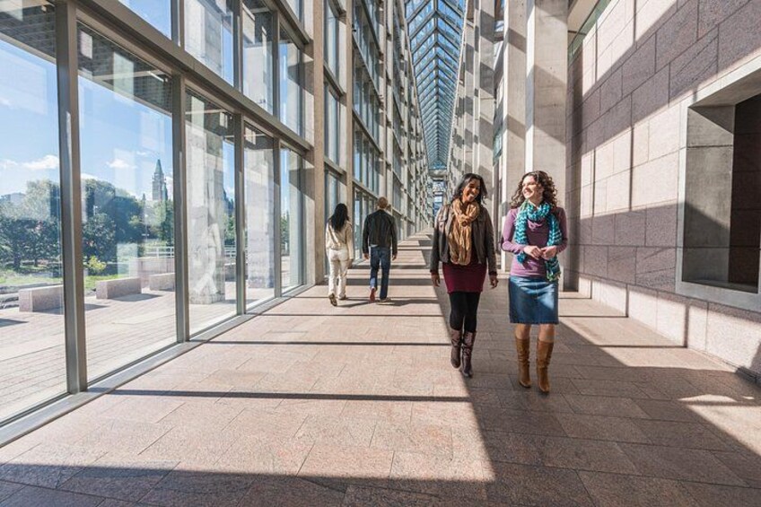 A corridor with large windows, a tiled floor, and a clear sky. 3