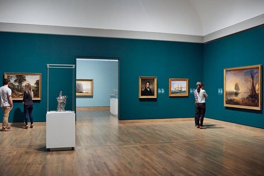 An art gallery with paintings on the walls and a white pedestal in the center. 5