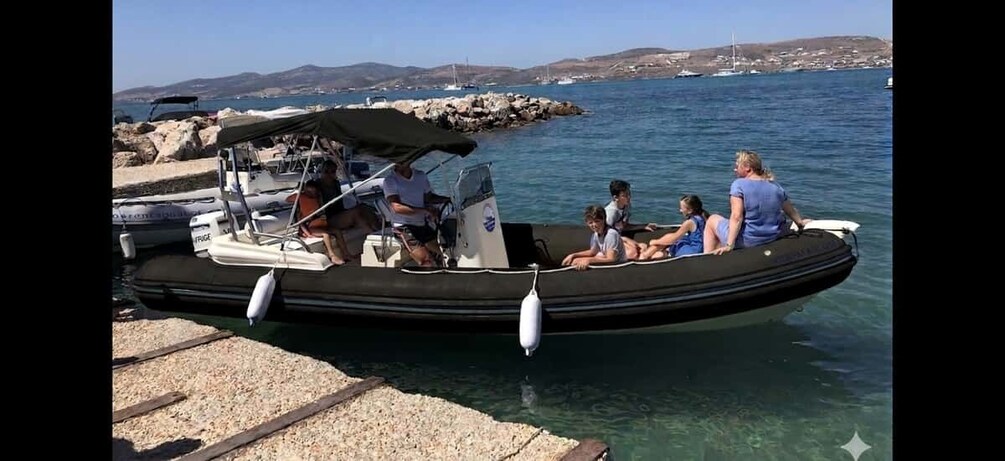 A small inflatable boat docked at a pier with people on board. 5