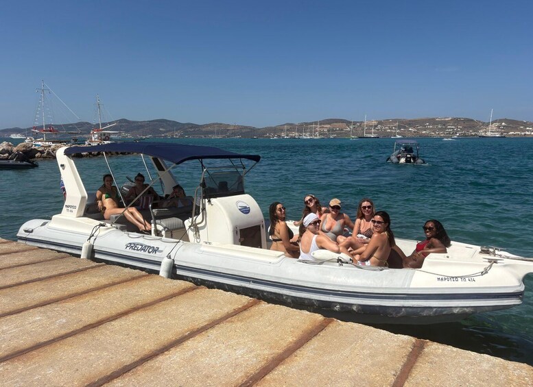 A group of people on a boat docked at a pier with a clear view of the water and distant hills. 4