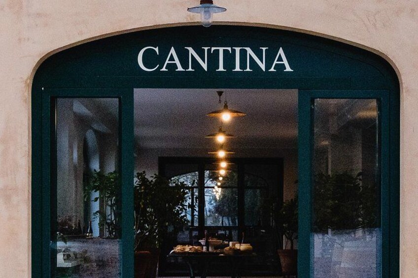 A restaurant entrance named 'CANTINA' with a dark archway, indoor lighting, and potted plants. 3