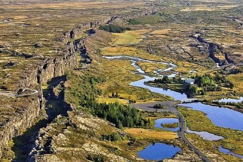 A rugged landscape with a river, rocky cliffs, and patches of greenery. 1