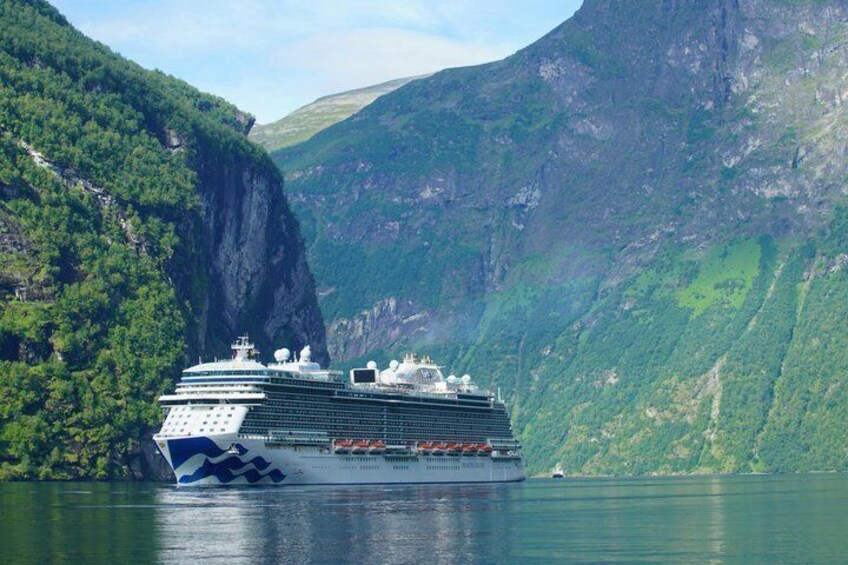 A cruise ship in a fjord surrounded by steep cliffs. 4