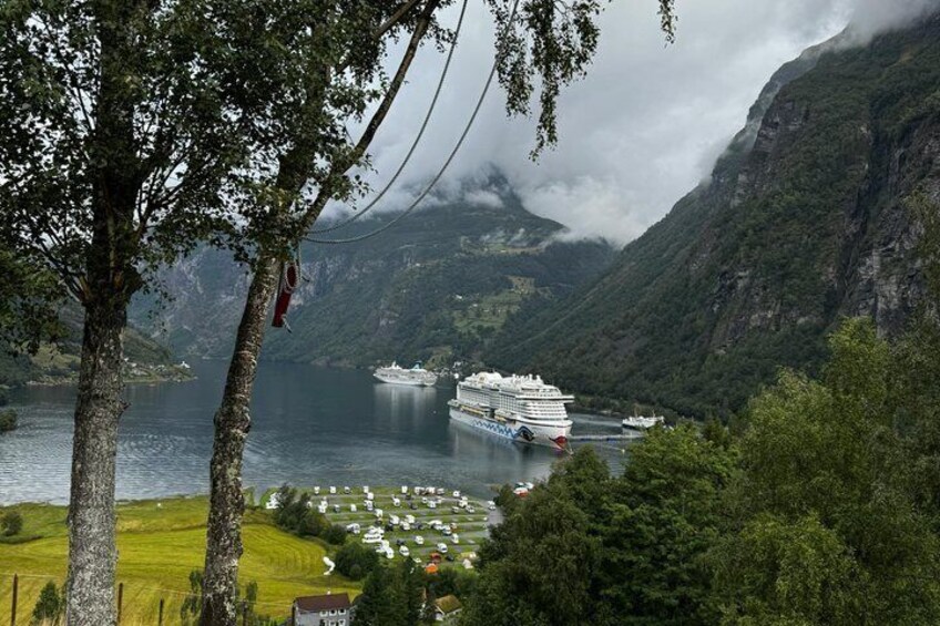 A cruise ship docked at a port with mountains in the background. 2