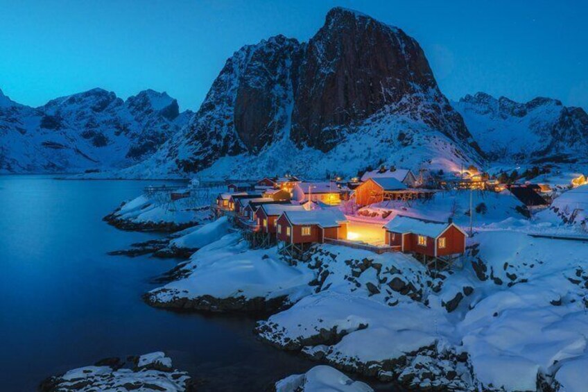 A snow-covered village with houses and a mountain in the background. 3
