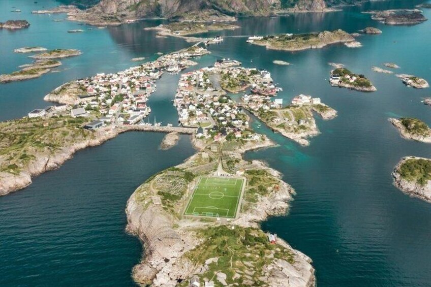 An aerial view of a coastal town with a central island featuring a soccer field. 5