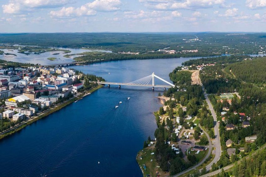 A river with a bridge, a town, and surrounding greenery. 1