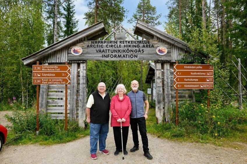 A wooden signpost with hiking trail directions and a forested background. 2