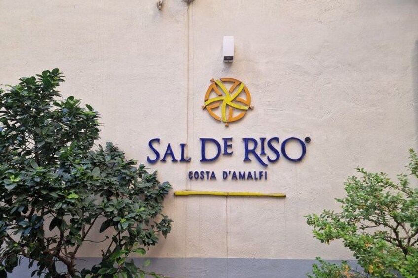 Letrero que dice 'SAL DE RISO COSTA D'AMALFI' con un logotipo amarillo y azul. 4