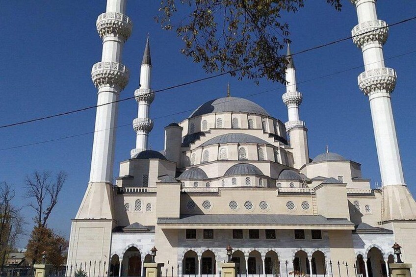 A mosque with four minarets, a large central dome, and arched windows. 4
