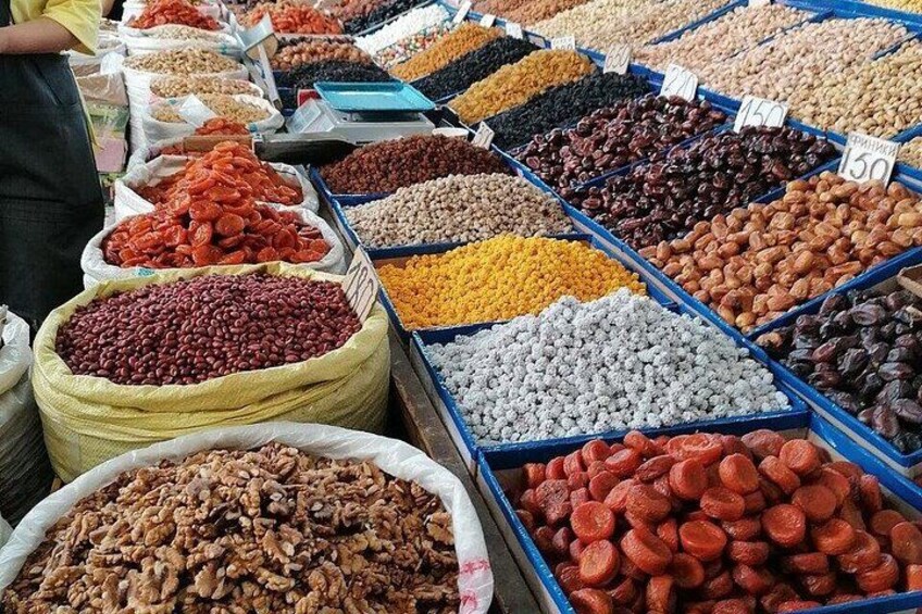 A market stall with various dried fruits and nuts in bins and sacks. 2