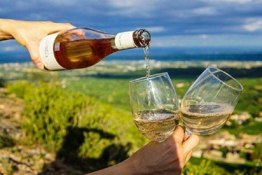 A person pouring wine into two glasses. 1